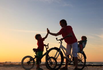 Biker family silhouette, father with two kids on bikes